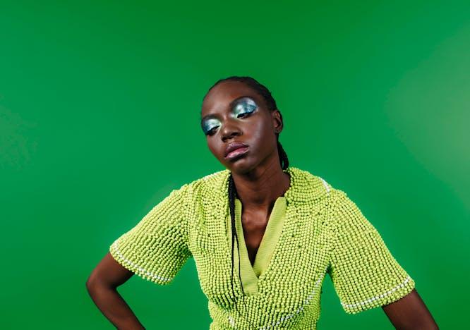 Model on green background in lime green bottega veneta look.