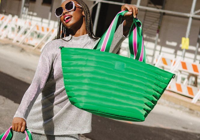 A woman carrying the Beach Bum Cooler Bag Maxi in green. / best-coolers