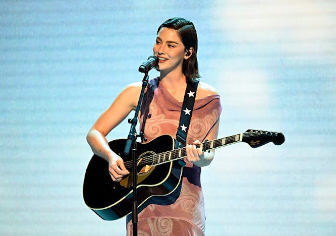Gracie Abrams wearing a light pink velvet gown from Prada while performing on 'The Tonight Show Starring Jimmy Fallon.' Photo courtesy of Getty Images.