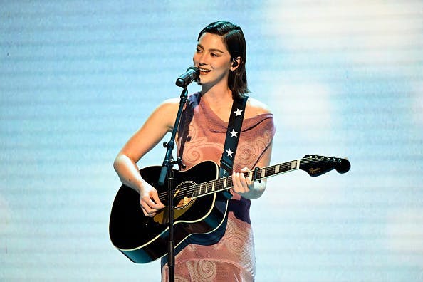 Gracie Abrams wearing a light pink velvet gown from Prada while performing on 'The Tonight Show Starring Jimmy Fallon.' Photo courtesy of Getty Images.