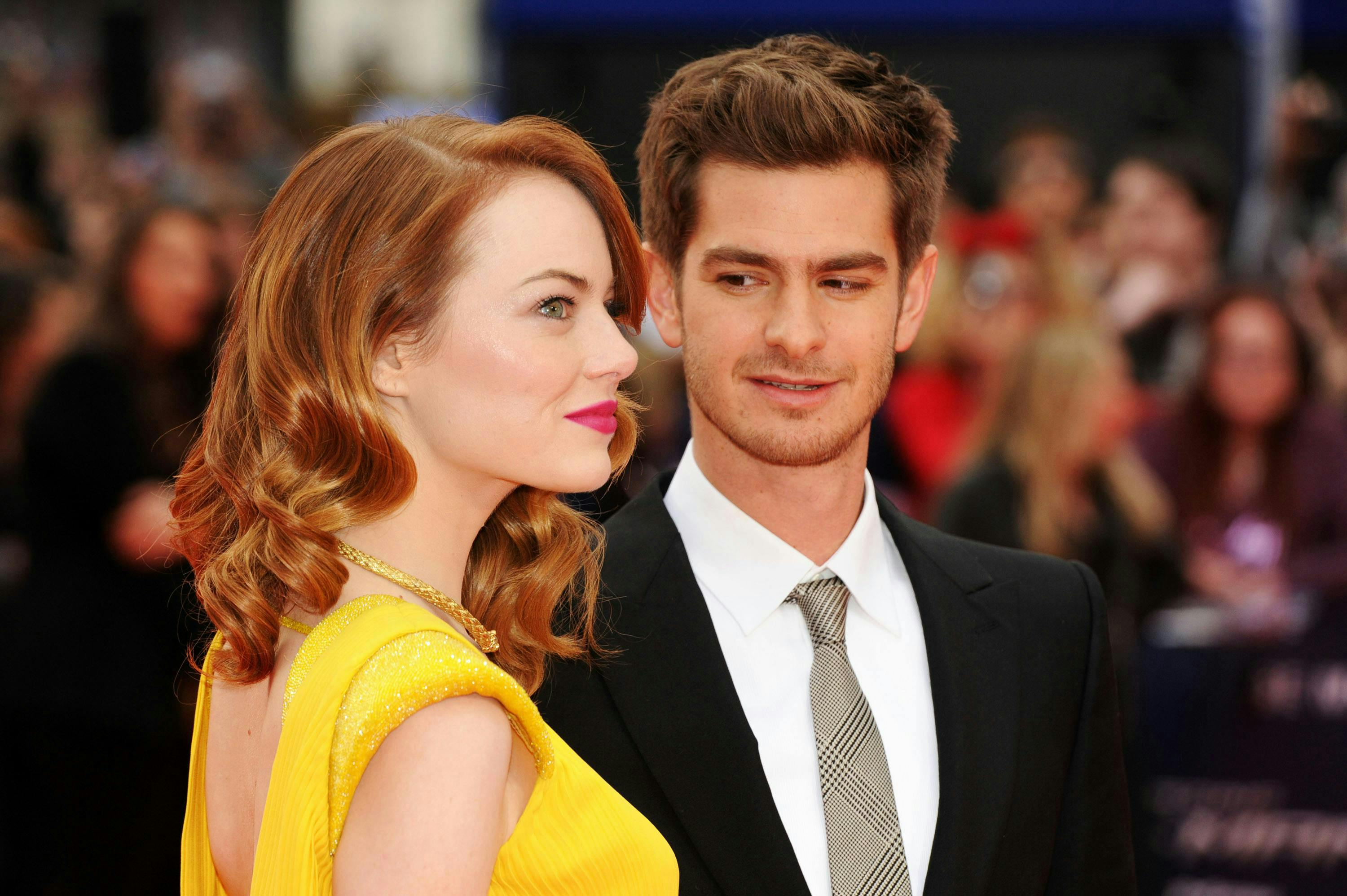 Andrew Garfield in a suit and tie and Emma Stone in a backless yellow dress at the premier of "The Amazing Spiderman 2"