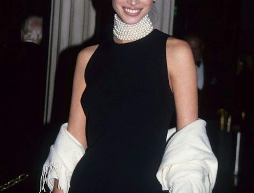 Christy Turlington in a black sleeveless dress and pearl choker
