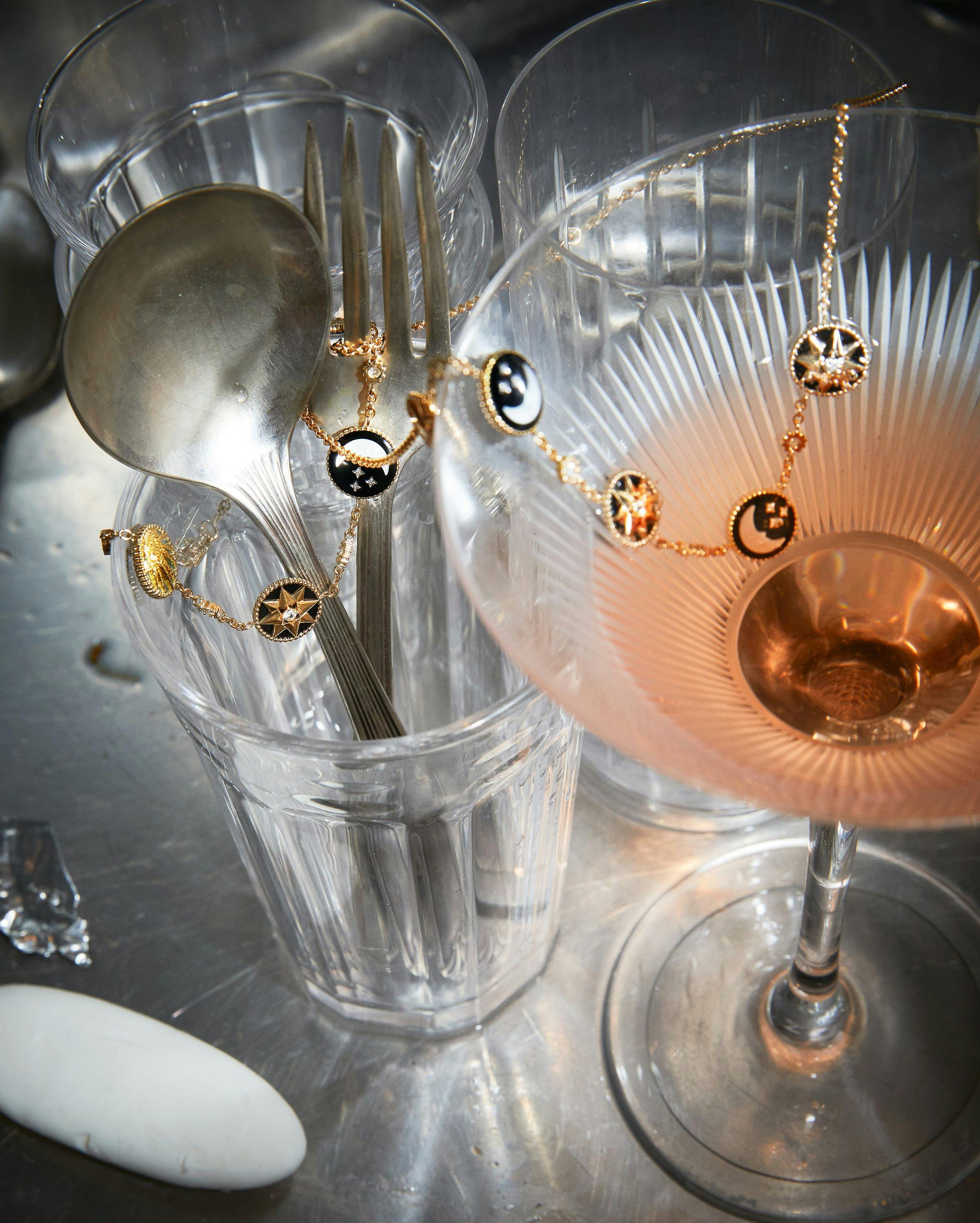 martini glass with pink drink, spoon and food in empty glass