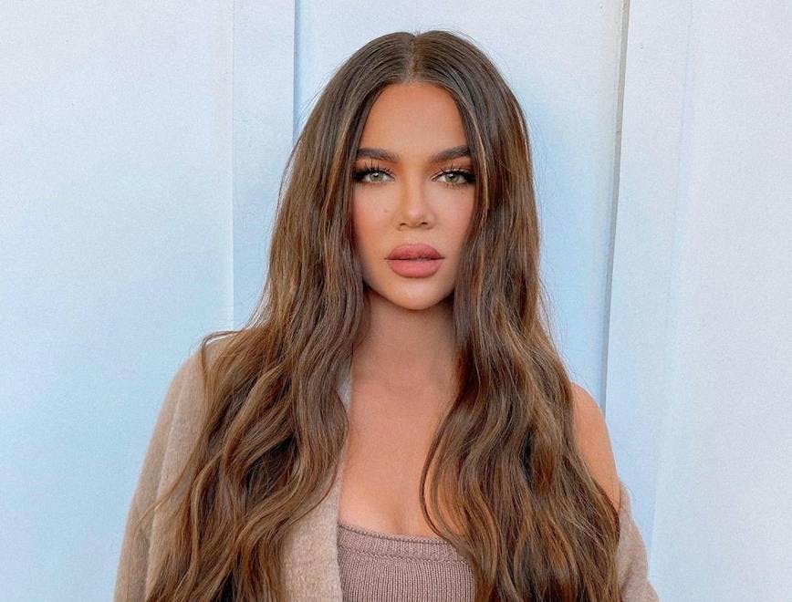 Khloé Kardashian with long hair in a brown outfit