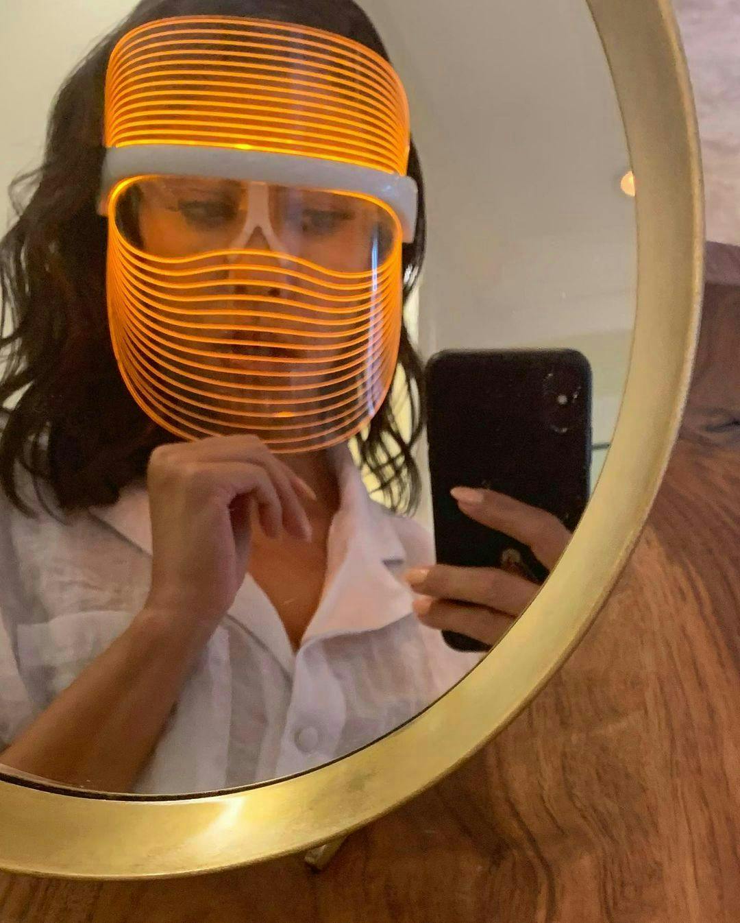 Kourtney Kardashian gold mirror orange LED light mask