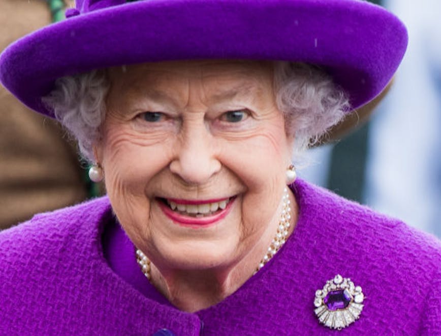 Queen Elizabeth wearing a purple suit and hat