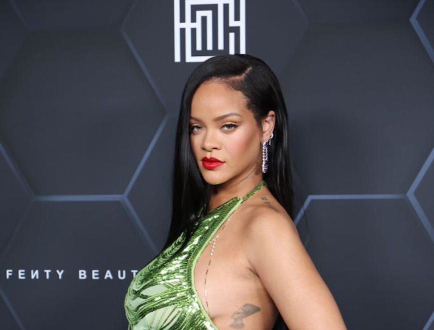 Rihanna in a green top and silver pants at a FENTY event