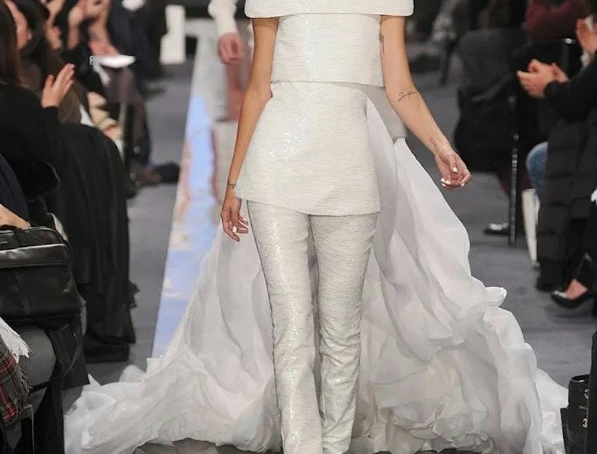 Model wearing a Chanel wedding dress in 2009 on a silver runway.