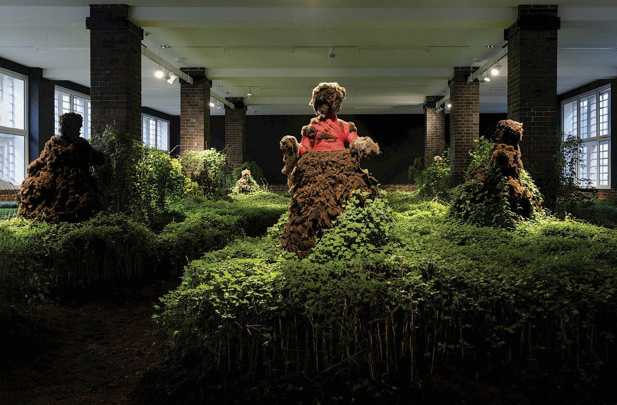 Green, brown, and pink moss like flowers cover women shaped figures to create ”Open circle Lived Relation (detail); Resistance is an atmospheric condition,” by Precious Okoyomon for the Venice Biennale. 