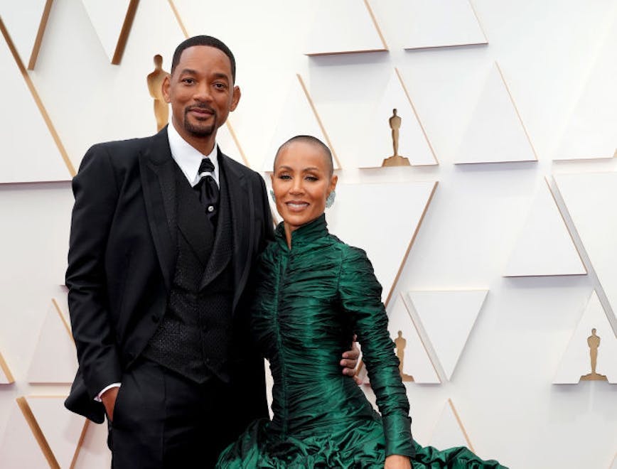 Will Smith in a black tuxedo and Jada Pinkett Smith in a fluffy green gown on the Oscars red carpet
