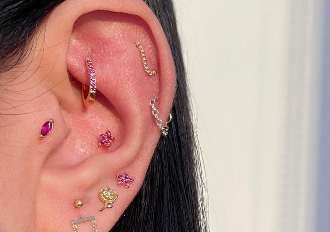 Close up photo of an ear with multiple piercings.