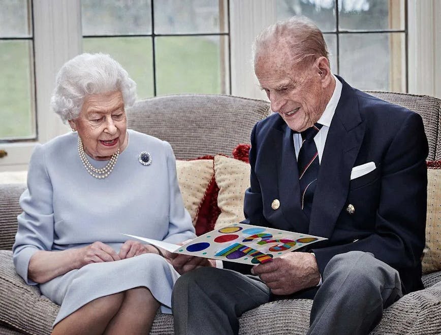 queen elizabeth and prince philip beside each other looking at a folder