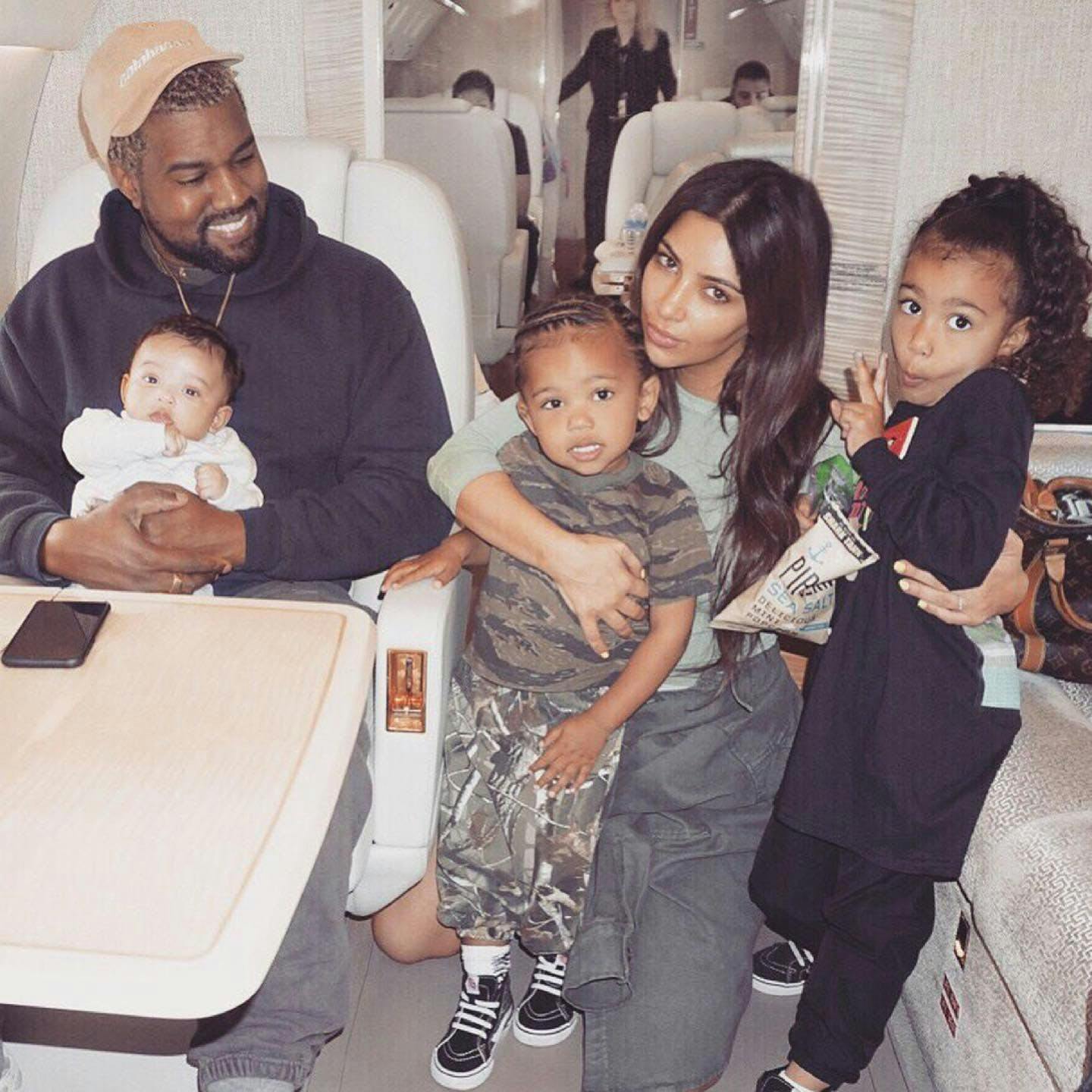 Kim Kardashian with Kanye West with their children, North West, Chicago West, and Saint West on an airplane.