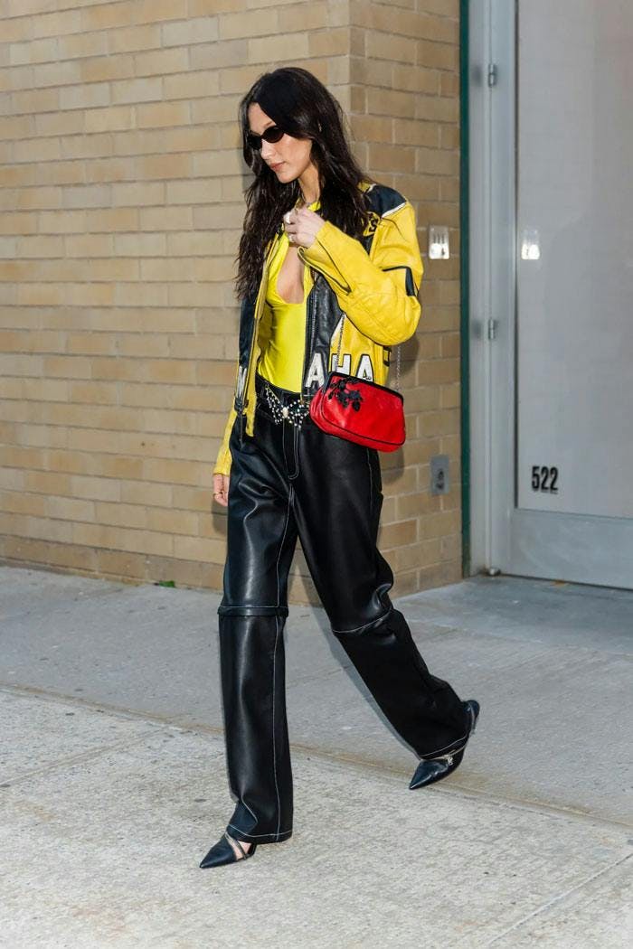 Bella Hadid wearing a yellow biker jacket and black leather pants