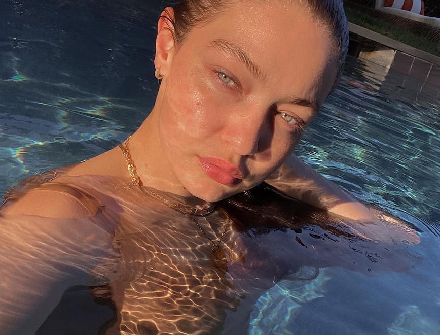Gigi Hadid swims in a pool without makeup on. 