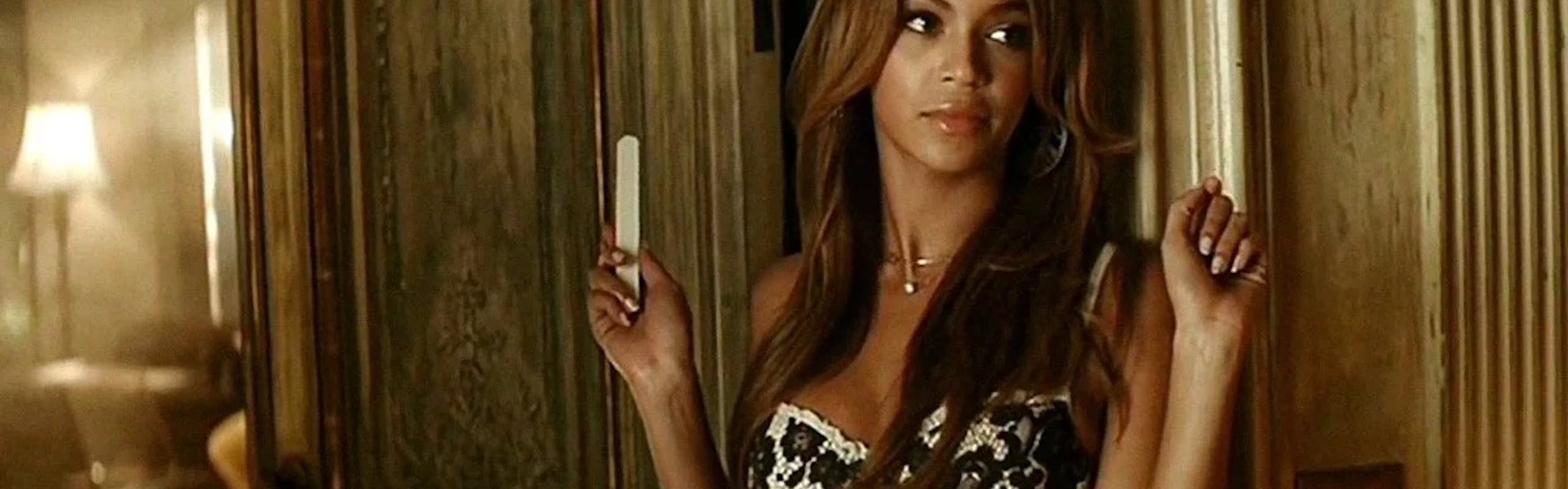 Beyonce in her music video for Irreplacable, holding a nail file and wearing a lace corset.