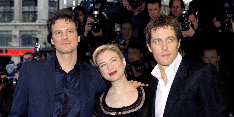 Colin Firth, Renée Zellweger, and Hugh Grant pose for a photo on a red carpet together.
