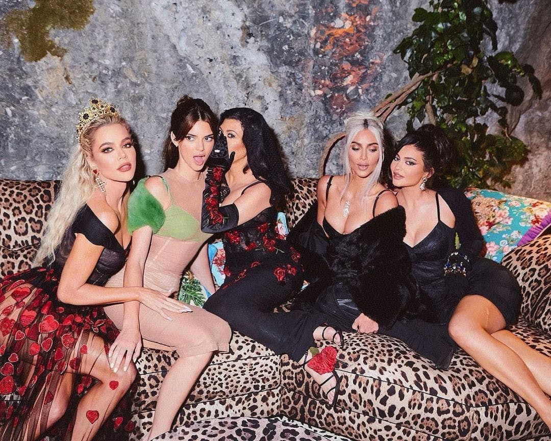 The Kar-Jenner sisters pose for a photo on a leopard couch.