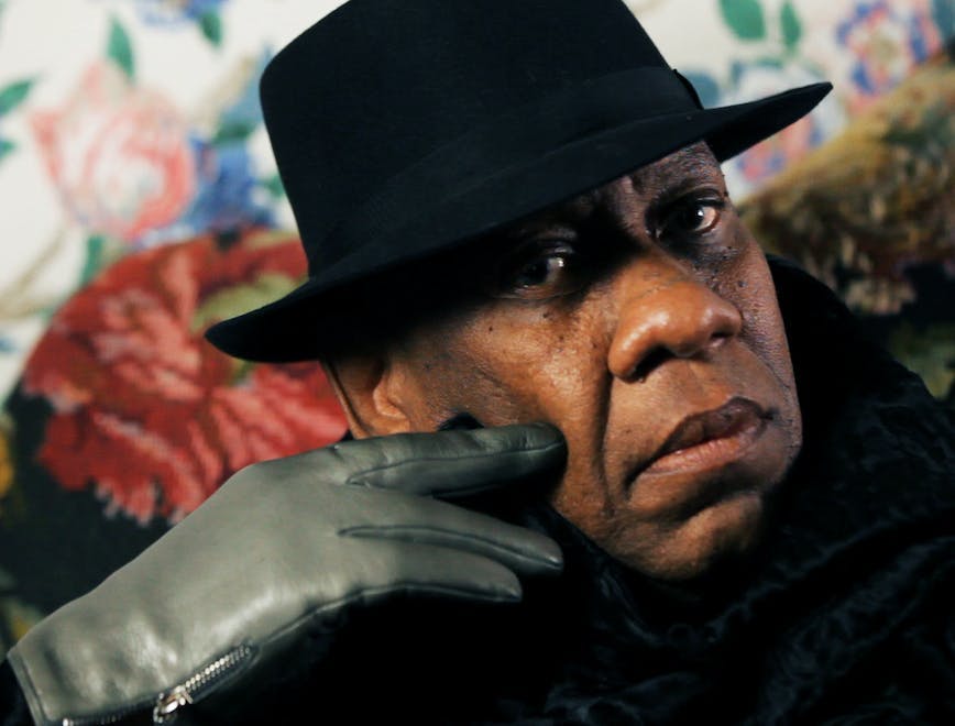 andré leon talley wearing a hat and leather gloves