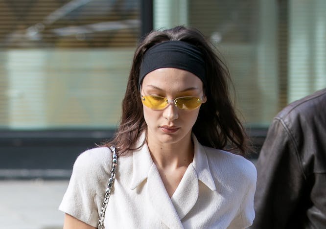 Bella Hadid wearing a thick black headband, a double-breasted top and tailored pants.
