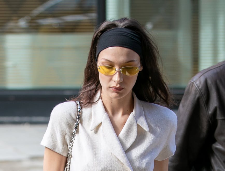 Bella Hadid wearing a thick black headband, a double-breasted top and tailored pants.