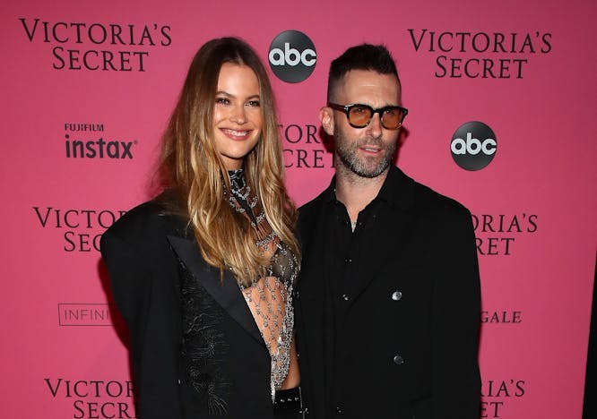 Behati Prinsloo and Adam Levine on a pink background