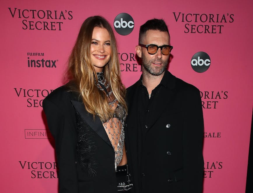 Behati Prinsloo and Adam Levine on a pink background