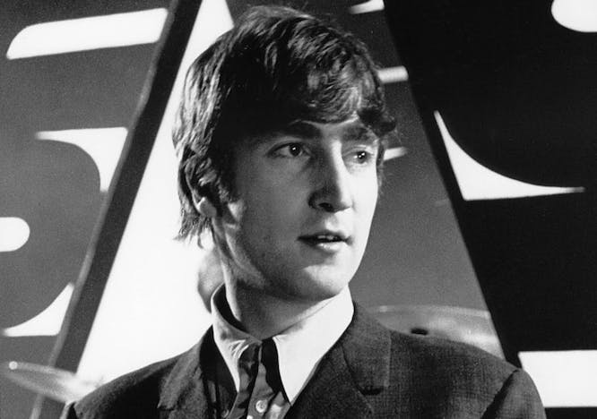 John Lennon in a suit while looking away from the camera.