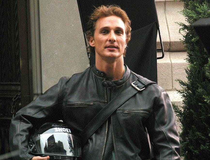 matthew mcconaughey wearing a leather jacket holding a motorcycle helmet
