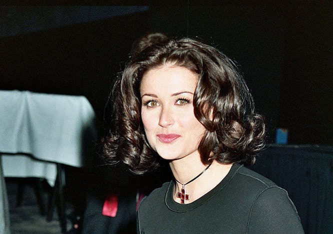 A woman wearing a black turtleneck while looking at the camera.