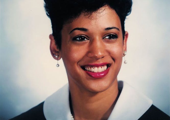 A woman smiling to the camera against a white and blue backdrop.