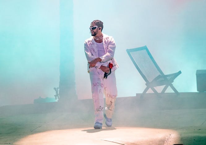 bad bunny on stage wearing all white and sunglasses