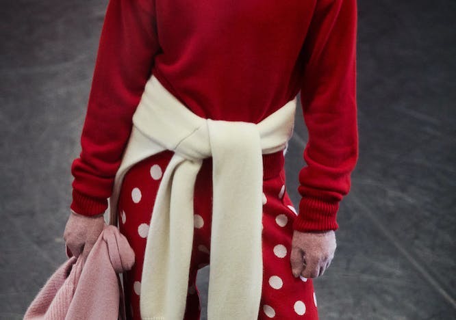 Model wearing red sweater and polka dots pants