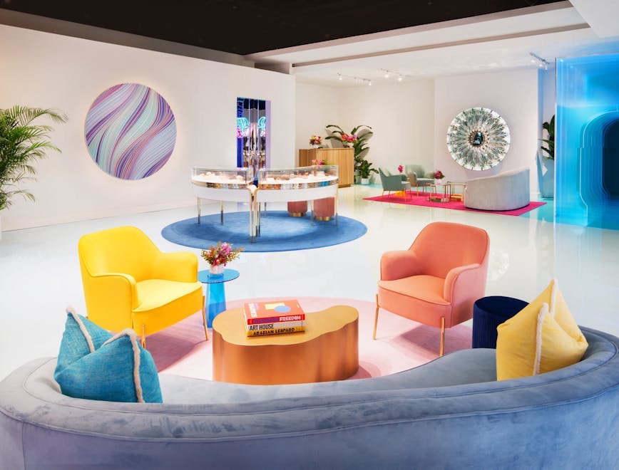 white room with yellow and pink chair blue couch blue wall art
