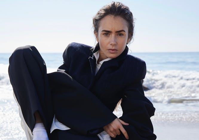 Lily Collins in a suit on the beach