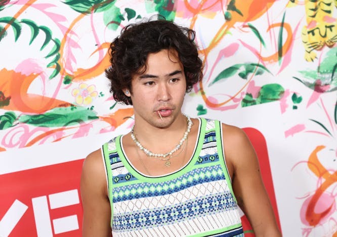 A man in a green printed tank looking away from the camera.