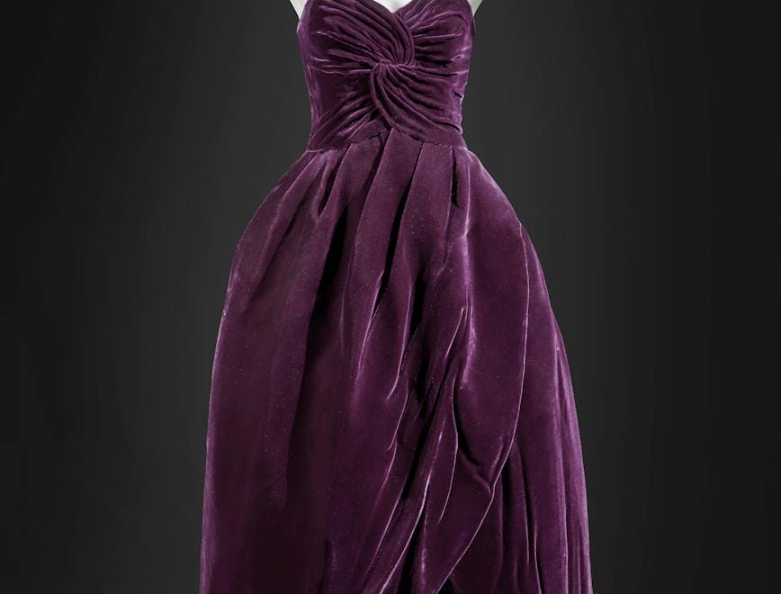 A purple dress set against a dark grey backdrop.