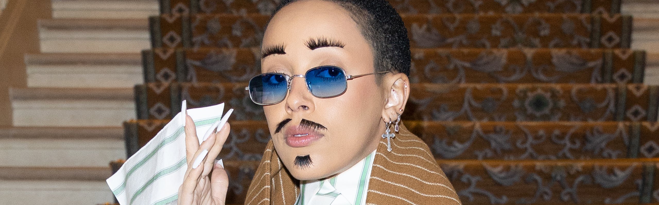 Doja Cat wears brown and white striped suit.