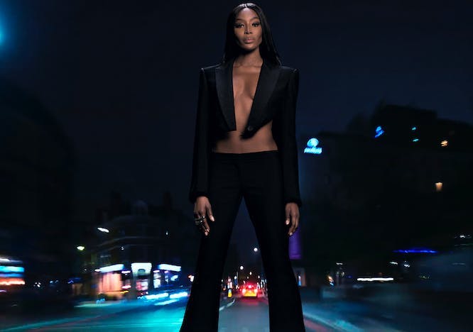 Naomi Campbell wears cropped black blazer and trousers.