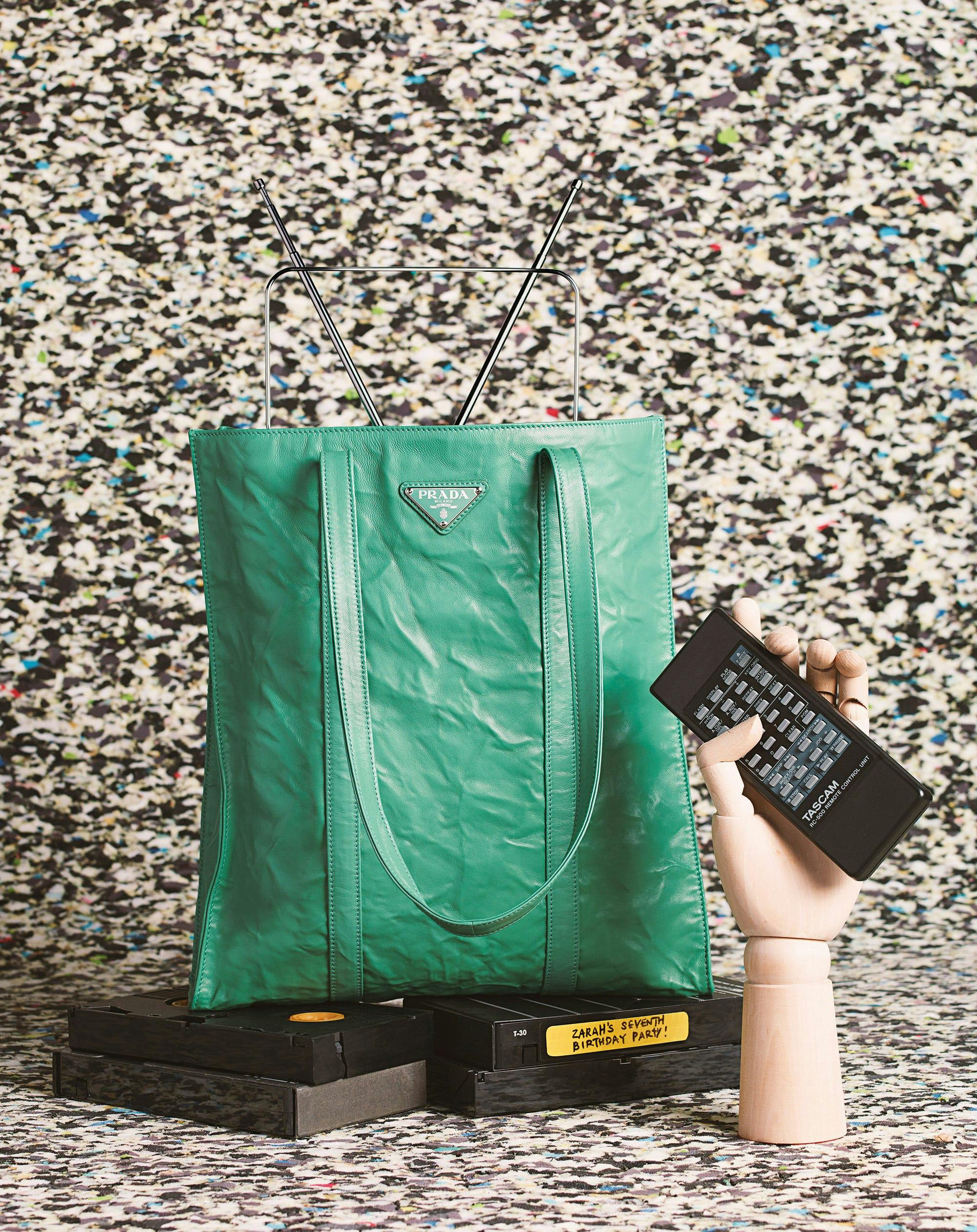 Green bag hand holding remote marble background