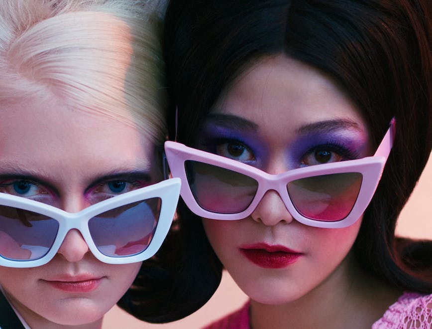 Two women wearing colorful sunglasses.