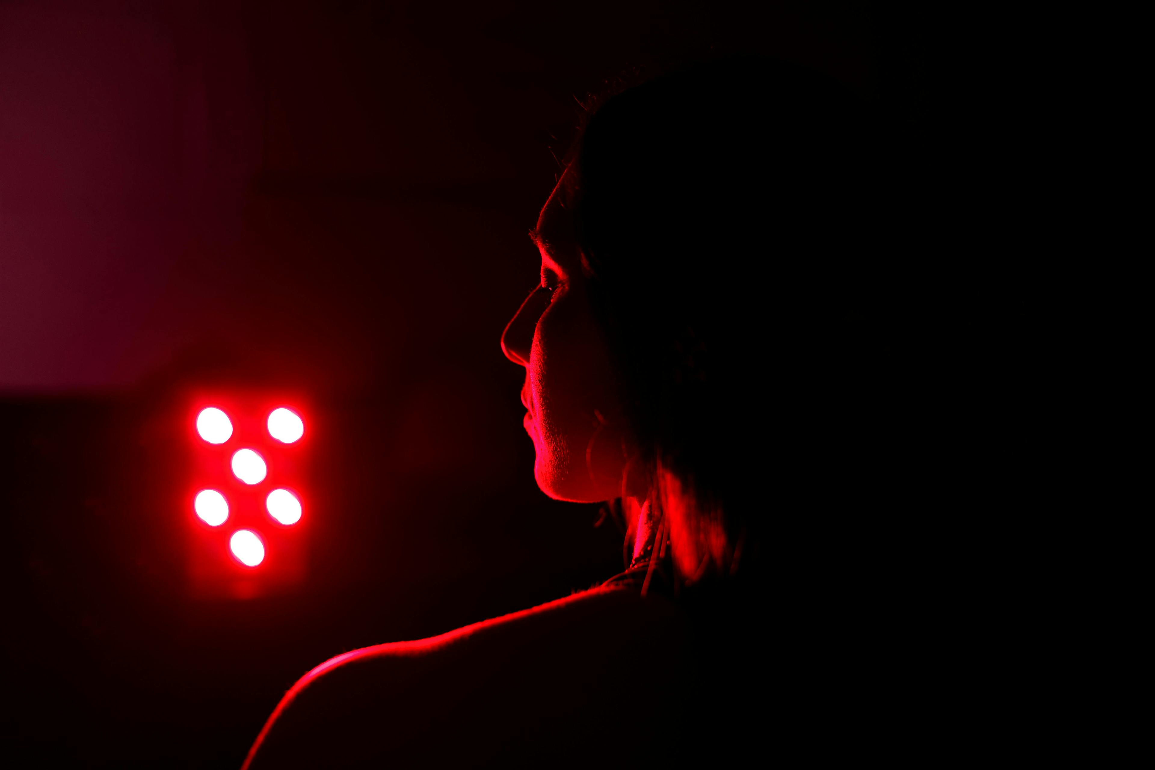 Woman standing in front of red light.