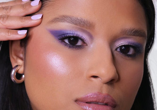 A model with purple eyeshadow looking at the camera.