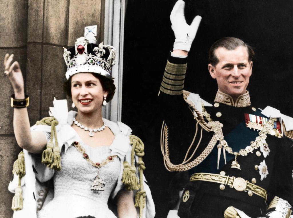 Queen Elizabeth and her husband waving to the crowd.
