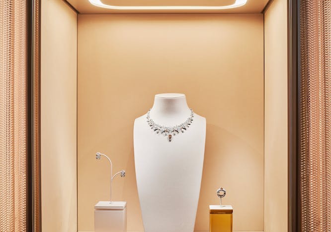 A Cartier necklace in a glass display case.