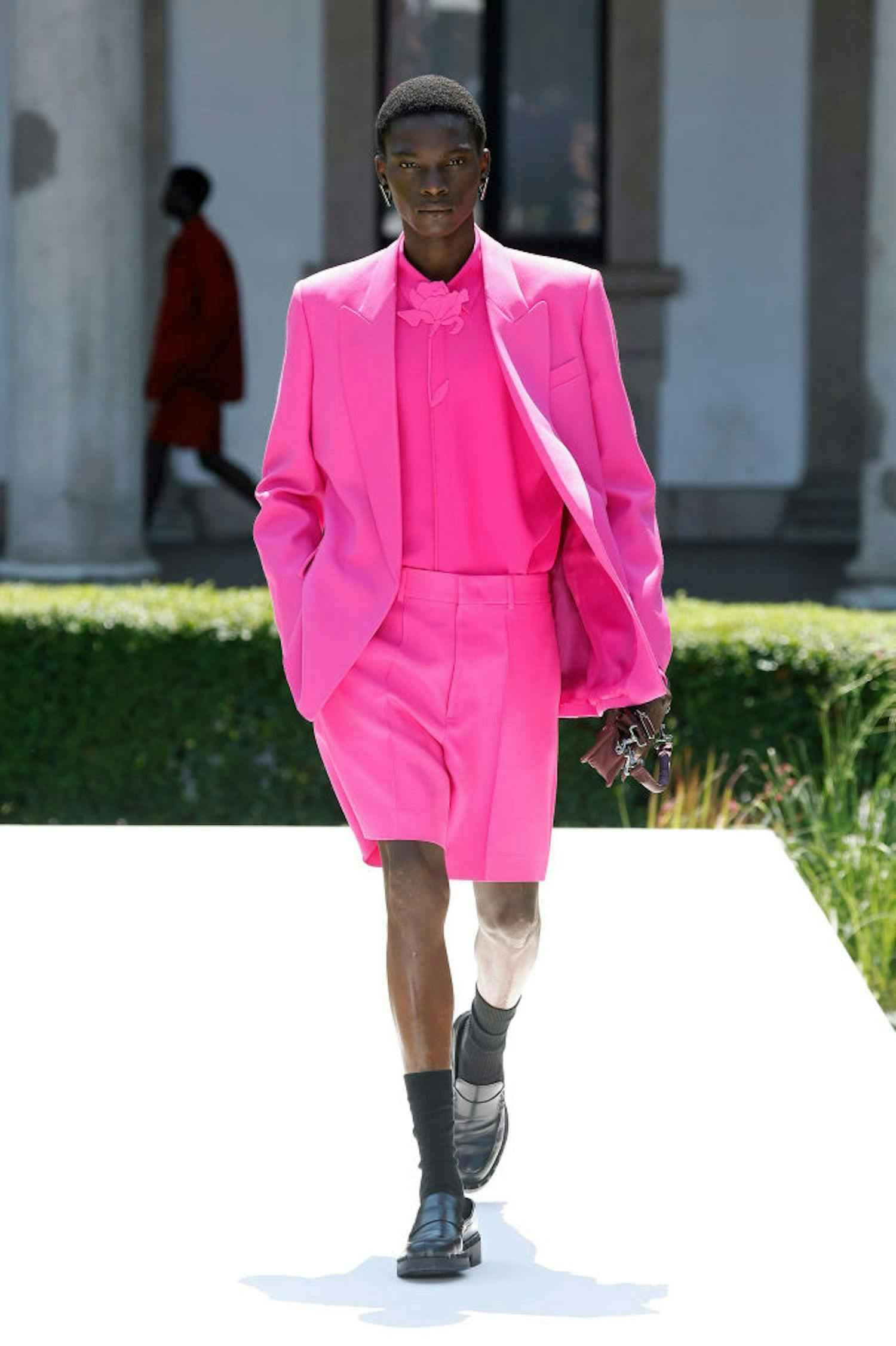 A model in a pink short suit.