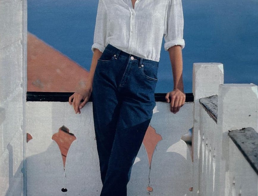 Woman wears white button down and blue jeans