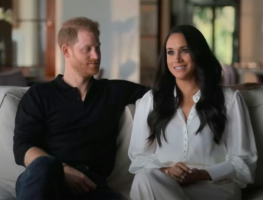 Prince Harry and Meghan Markle sitting on a couch