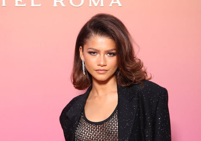 zendaya with a bob at a bulgari event, wearing a black blazer, mesh top, and black trousers