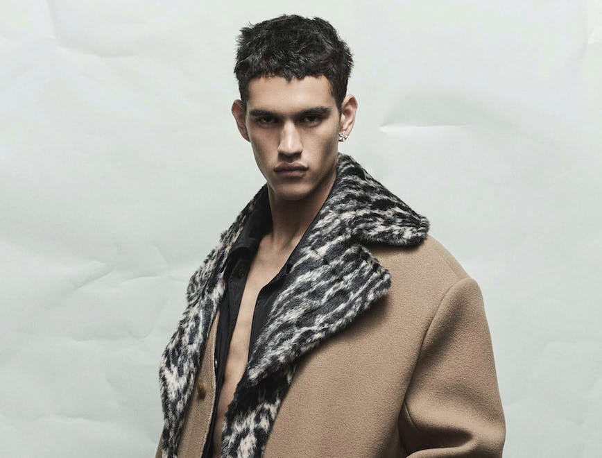a model in a camel coat lined with grey and black print fur